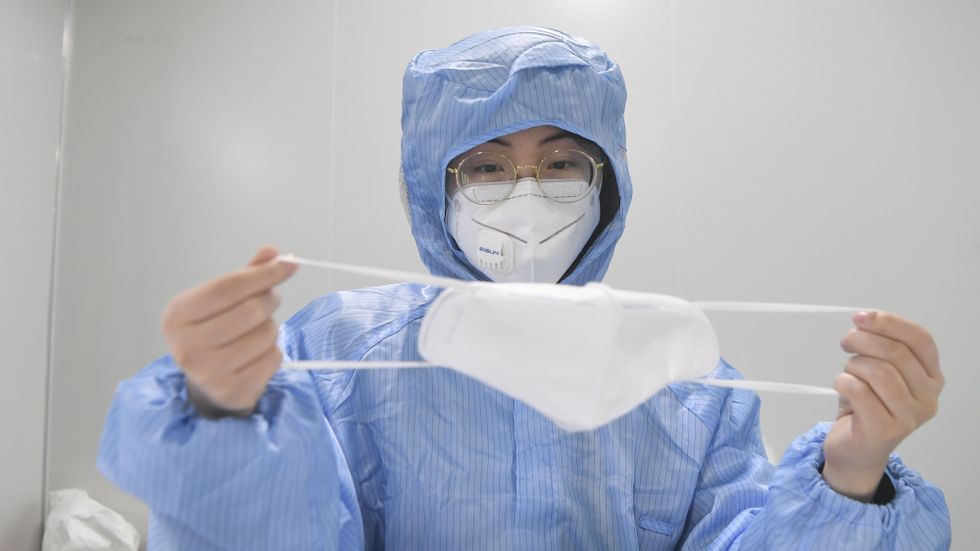 Tillverkningen av munskydd går på högvarv i ett Kina drabbat av coronaviruset.