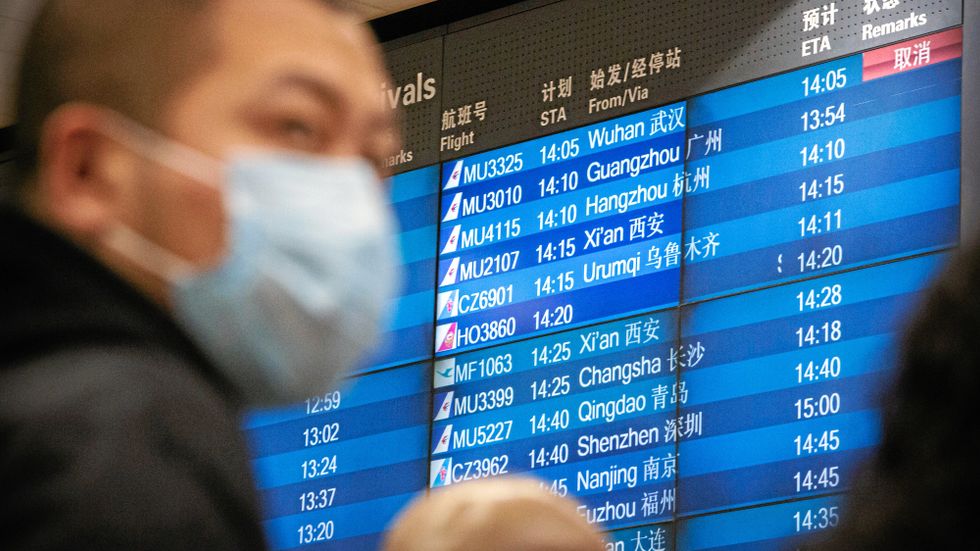 En flygresenär i Peking utrustad med munskydd. 