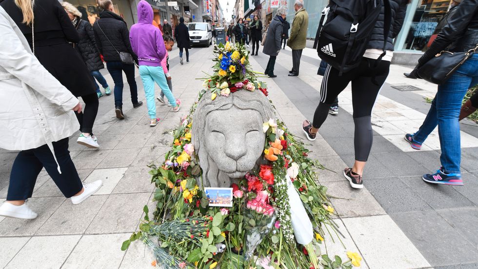Ett betonglejon täckt av blommor på Drottninggatan i Stockholm, efter terrordådet 7 april. Arkivbild.