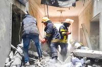 Räddningsarbetare på plats i en byggnad som skadats i centrala Charkiv.
