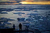 Forskare står på den finska isbrytaren MSV Nordica och ser ut över Arktis, medan solen går ner över havsisen som flyter runt i strömfåran Victoria Strait. Forskning visar att Arktis värms upp dubbelt så fort som den övriga planeten. 