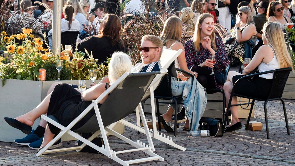 Folk på en uteservering i Helsingfors den 17 juli – första fredagen efter att regeringen lättade på restriktionerna.