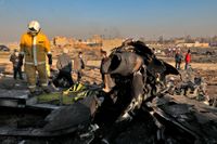 Räddningsarbetare på platsen där det ukrainska flygplanet störtade sedan det skjutits ned utanför Teheran den 8 januari.
