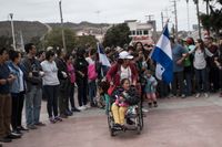En familj som deltagit i vandringen mot den amerikanska gränsen på väg att lämna in sina asylansökningar till amerikanska myndigheter vid den mexikanska gränsstaden Tijuana i söndags.
