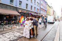 Ungdomar omfamnar varandra på platsen för masskjutningen i centrala Oslo i juni.