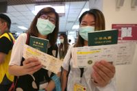 Resenärer håller upp sina taiwanesiska pass.