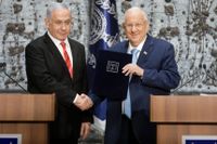 Israeli president Reuven Rivlin ( t h) skakar hand med premiärminister Benjamin Netanyahu som fått i uppdrag att bilda ny regering.