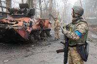Ukrainsa soldater undersöker ett militärfordon utanför Irpin, i början av april.