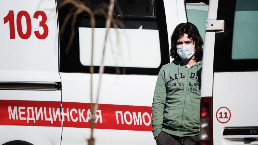 En man med ansiktsmask vid ett bygge av ett nytt sjukhus i ryska Kommunarka.