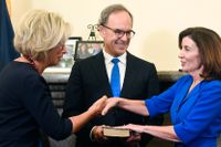New Yorks högsta domare Janet DiFiore (till vänster i bild) lyssnar när Kathy Hochul svär ämbetseden som delstatens första kvinnliga guvernör. I mitten står den nye guvernörsmaken Bill Hochul.