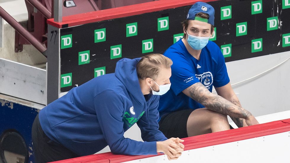 Vancouvers svenske backstjärna Alexander Edler, till vänster, och Jake Virtanen iförda munskydd under träningslägret inför NHL-säsongen.