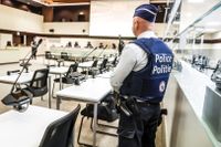 En polis på plats i den ombyggda rättegångssalen i Bryssel där de åtalade för terrordåden 2016 nu ställs inför rätta.