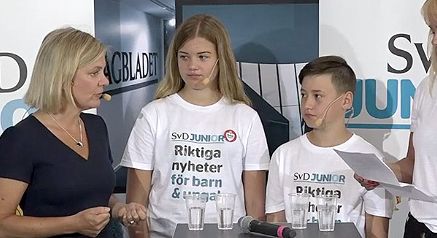 Magdalena Andersson ställs mot väggen av juniorreportrarna Erik, 12 år, och Maria 13, år.