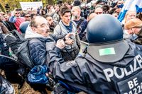 Polis griper in mot en demonstration mot coronarestriktioner utanför riksdagshuset i Berlin, säte för tyska Förbundsdagen.