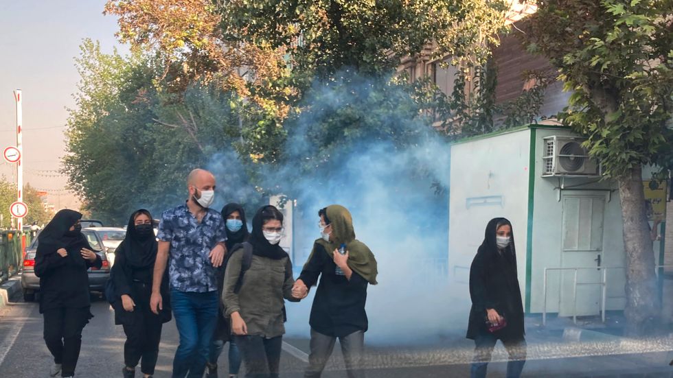 Tårgas används för att skingra de demonstrerande i Irans huvudstad Teheran. Bilden är tagen i lördags.