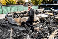 Jan Kajan går bland de uppbrända bilarna alldeles intill sin bostad. Hans egen bil klarade sig precis.