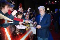George Lucas skriver autografer vid biopremiären av den nya Star Wars-filmen i London.