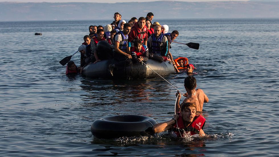 En gummibåt med flyktingar från Syrien och Afghanistan anländer till grekiska ön Lesbos, den 27 juli i år.