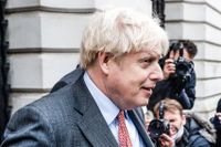 Storbritanniens premiärminister Boris Johnson passerar förbi julgranen på 10 Downing Street i London.
