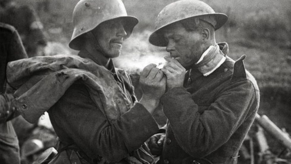 En tysk soldat ger eld till en brittisk soldat under julfreden 1914 under första världskriget.