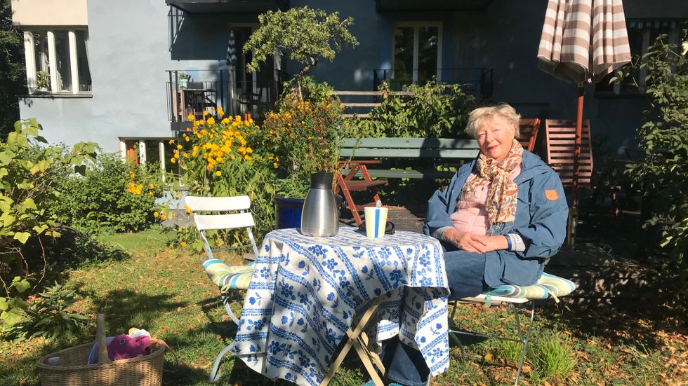 Lena Sjöberg i solskenet utanför sitt kära blå hus.