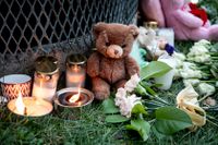 Gosedjur, blommor och ljus vid den plats där två barn hittades med livshotande skador utanför ett bostadshus i Hässelby i november. Ett av barnen avled och deras pappa åtalas nu. Arkivbild.