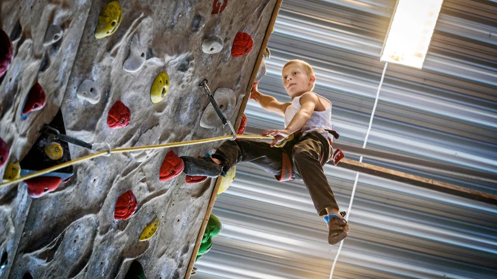 Här klättrar Simon, 11, med rep på den höga klätterväggen på Klätterverket i Nacka utanför Stockholm.