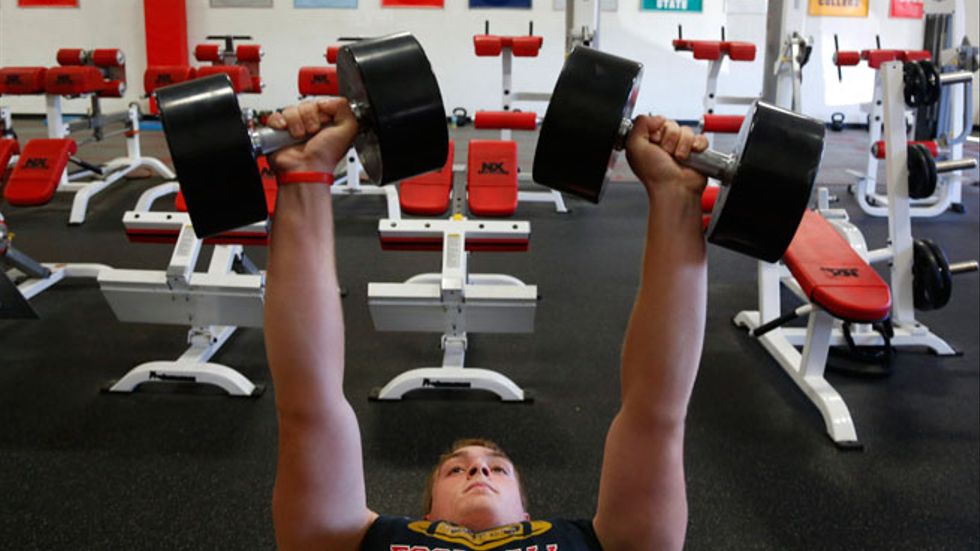 16-årige Billy Hirschfield tränar med hantlar i Waukesha, USA. Där rekommenderas barn och ungdomar att styrketräna minst tre gånger per vecka, skriver artikelförfattaren.