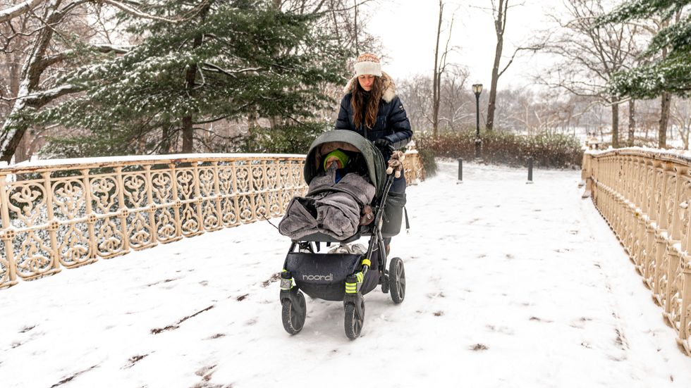 En kvinna drar barnvagn genom snön i Central Park, New York.
