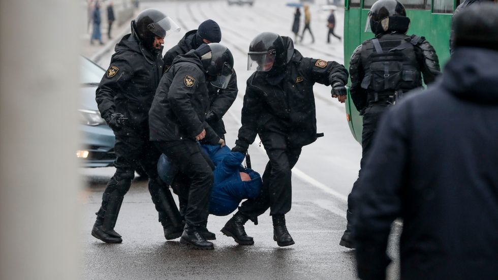 Vitrysk polis i huvudstaden Minsk bär bort en demonstrant under protesterna den 25 mars.