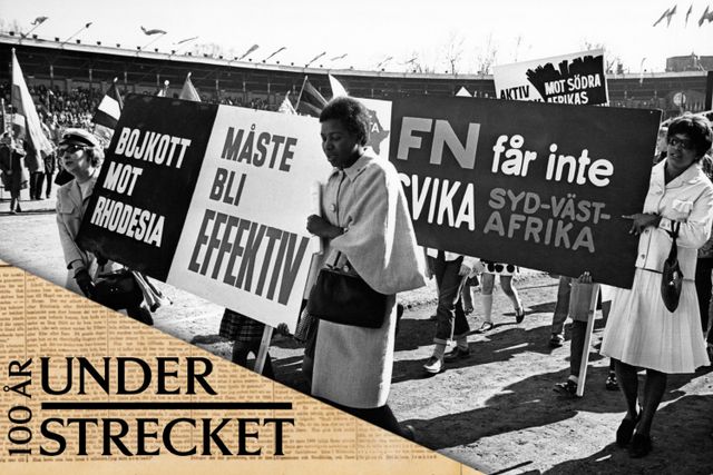 Demonstranter på Stockholms Stadion under första maj-firandet 1966. Skyltarna manar till bojkott mot Rhodesia och att FN inte får svika Sydvästafrika. 