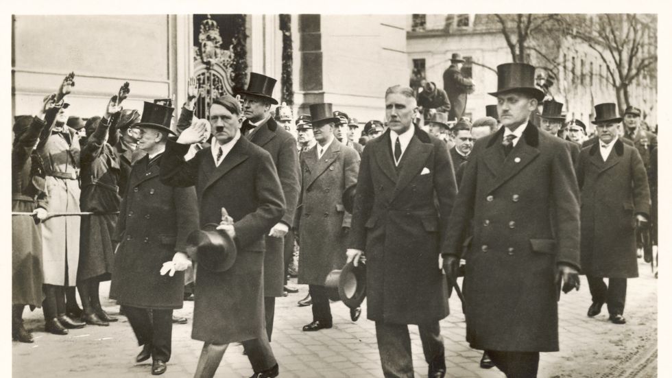 Adolf Hitler tågar genom Potsdam med en cylinderhatt i handen i mars 1933.