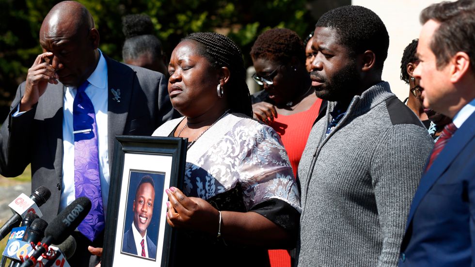 Irvo Otienos mamma Caroline Ouko håller ett fotografi av sin son som avled på ett sjukhus för psykiatrisk vård.