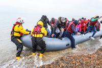  Migranter hjälps iland efter att ha anlänt till brittiska kusten. 