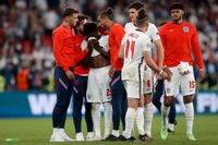 De engelska spelarna försöker trösta sin lagkamrat Bukayo Saka efter straffmissen.