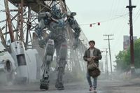 Anthony Ramos bredvid en Transformer-robot. 