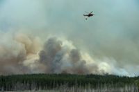 En helikopter vattenbombar utanför Gammelby under släckningen av den omfattande skogsbranden i Västmanland förra sommaren.