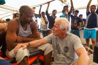 Skådespelaren Richard Gere pratar med en migrant ombord fartyget Open Arms 2019.