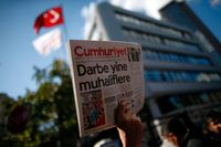 En man håller upp det sista nummer av Cumhuriyet som hann komma ut innan turkisk polis slog till mot tidningen den 31 oktober.