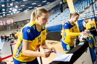 Johanna Westberg, närmast kameran, skriver autografer efter segern mot Norge – eller förbereder hon lördagens frågesport? I bakgrunden med ryggen mot kameran: roliga gruppens andra medlem Hanna Blomstrand.