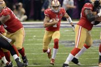 San Francisco 49ers quarterback Colin Kaepernick (med bollen) startade traditionen att knäböja under nationalsången i protest mot rasismen inom NFL.