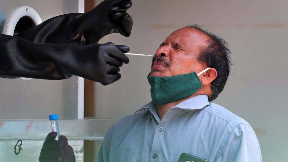 En man testas för coronaviruset på ett sjukhus i Hyderabad i Indien.