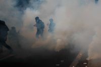 Aktivister flydde från tårgas under en förstamajdemonstration i Paris.