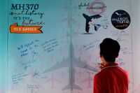 En man skriver en kondoleans under en minnesdag för det försvunna planet MH370 i Kuala Lumpur, Malaysia. Planet tillhörde Malaysian Airlines. Arkivbild.