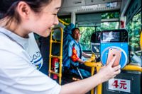 En person använder betaltjänsten Alipay för att betala sin bussresa.