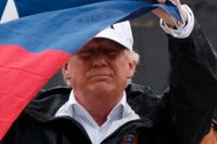President Donald Trump håller upp Texas flagga efter att besökt en brandstation i Texas, där han och flera andra diskuterade åtgärder efter Harveys framfart. 