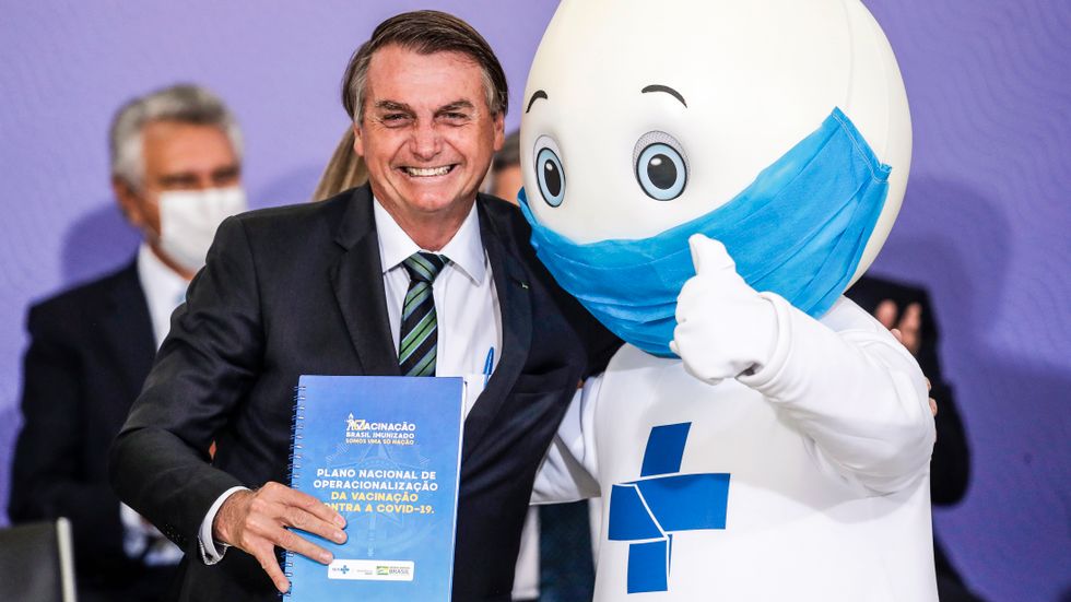 Brasiliens president Jair Bolsonaro tillsammans med landets vaccinmaskot.