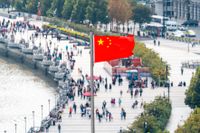En kinesisk flagga ovan ett promenadstråk i Shanghai. 
