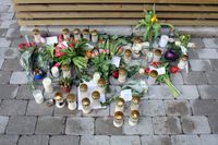 Blommor och ljus på gatan i Malmö där en kvinna knivhöggs till döds framför sin två små barn.