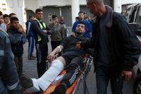 En man som skjutits i benet förs till vård i staden Gaza på fredagen.